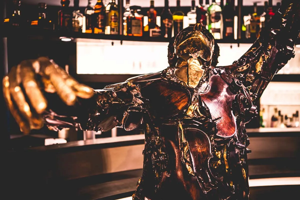 Bronzen beeld van een dansende figuur voor de bar