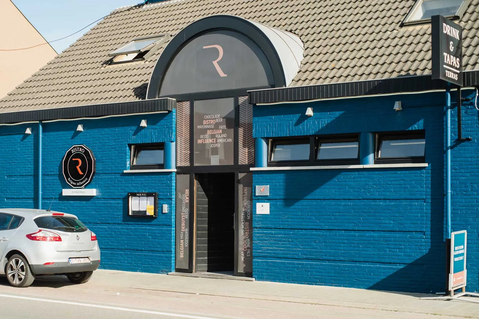 De blauwe gevel van Bistro R met het logo boven de ingang