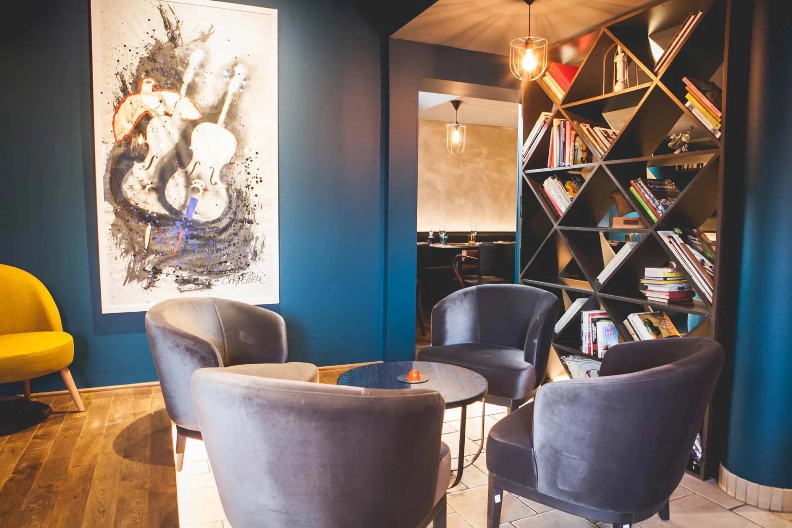 Loungehoek met bruine fauteuils onder een groot kunstwerk