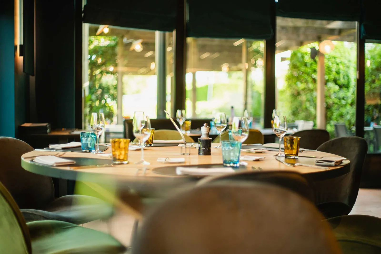 Gedekte ronde tafel bij het raam, met zicht op het groen