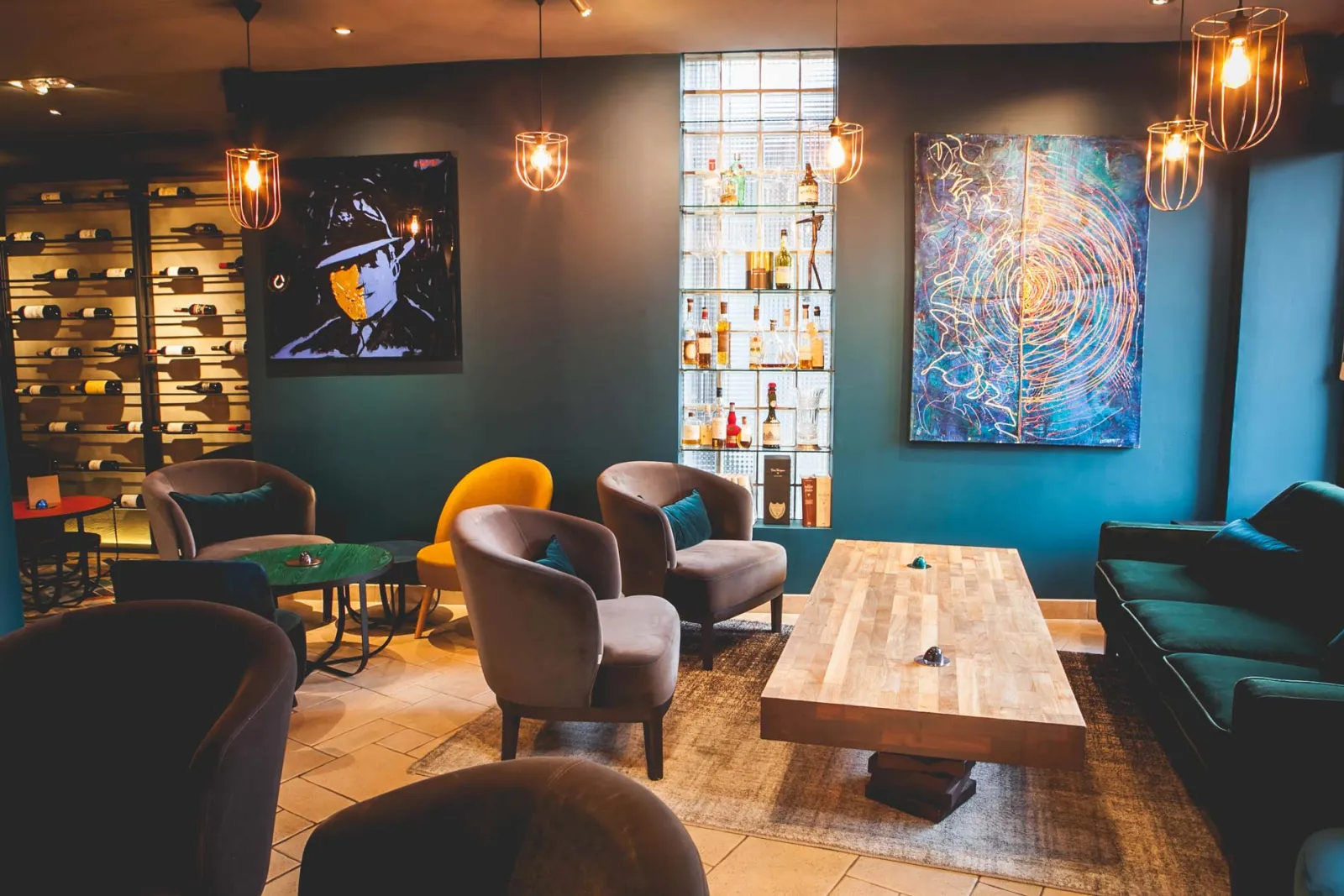 Eetzaal met kunstwerken, wijnrek en een grote houten tafel