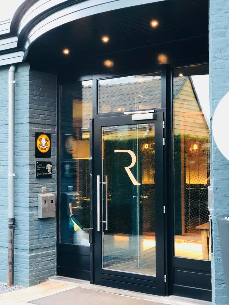 De glazen voordeur van Bistro R met het R-logo, gezien vanaf de straat