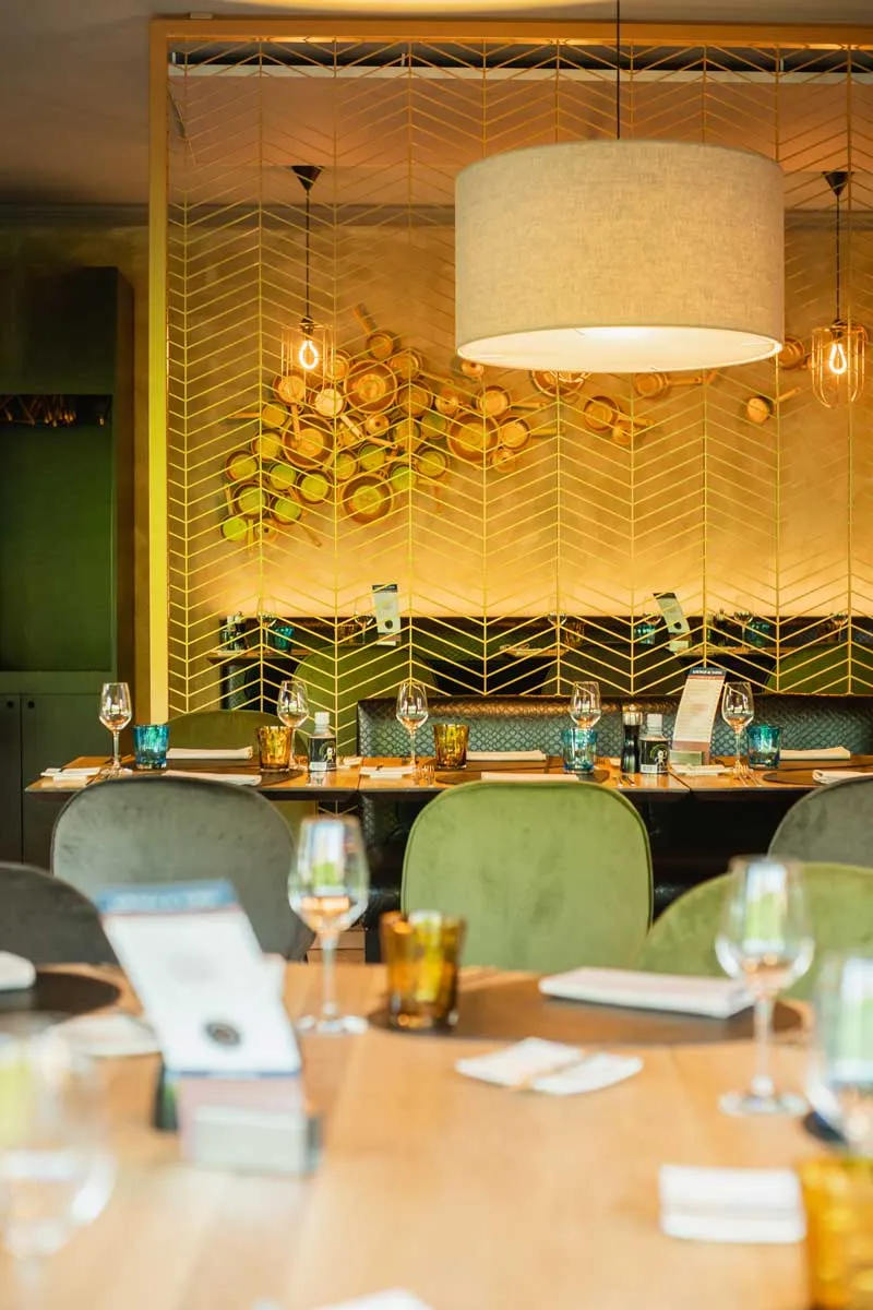 Gedekte tafel onder een ronde hanglamp, tegen een honingraatpaneel